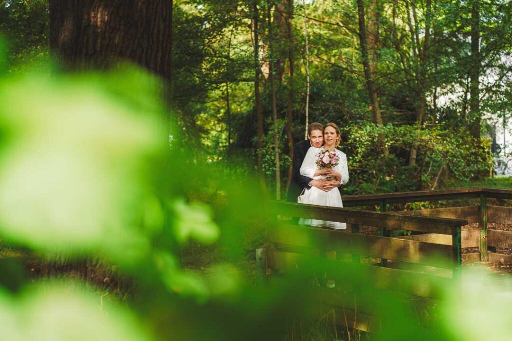 Brautpaarfoto im Wald mit Vordergrundelement in Farbe